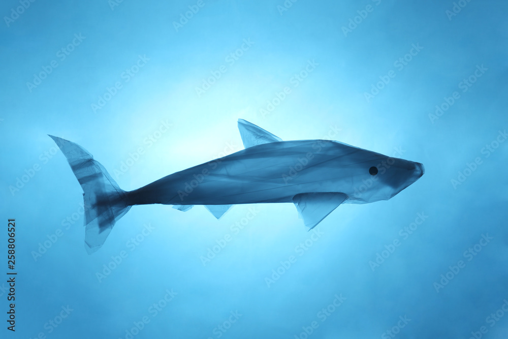 Pollution of the environment of the planet plastic. Blue plastic bag in the shape of a fish in the world ocean. Pollution of the environment of the planet plastic. Blue plastic bag in the shape of a fish in the world ocean.