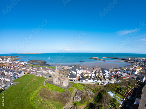 aerial view of buildings, houses on Coast of Irish Sea against clear blue sky. Castle on hill in Donaghadee, Northern Ireland