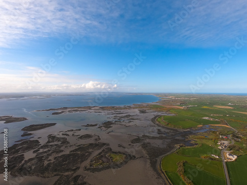 Aerial view of green fields and coast of Irish Sea in Northern Ireland. Coastal Route 