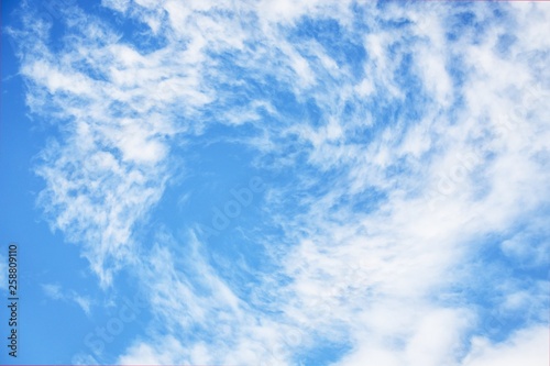 Light blue sky with cirrocumulus clouds. Whirlpool, funnel or swirl effect