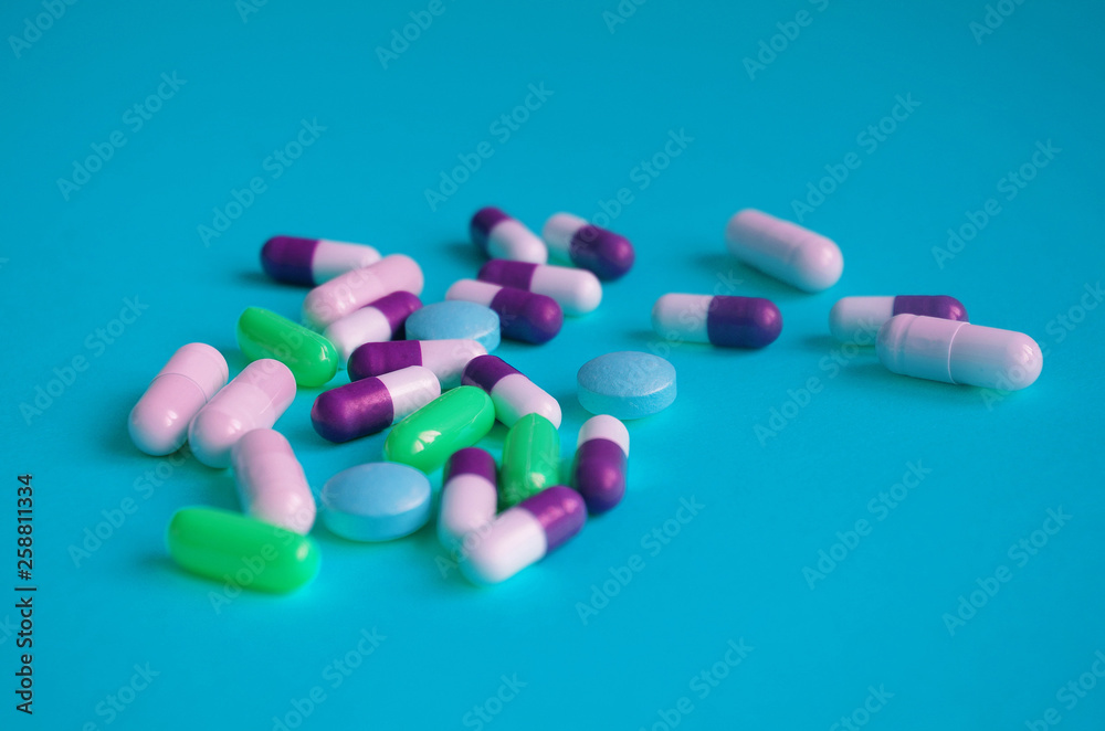 Color pills on blue background. Pharmaceutical medicine concept.