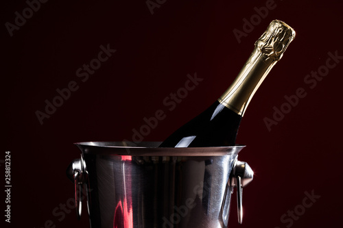 Sparkling wine bottle in ice bucket. Champagne in cooler.