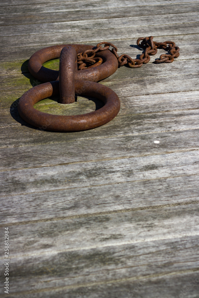Rusty boat mooring rings on timber quayside Rusty boat mooring rings on timber quayside
