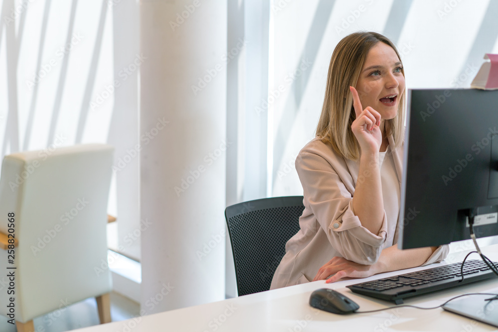 Young beautiful caucasian girl thumbs up happy and exalted in the office in front of the computer