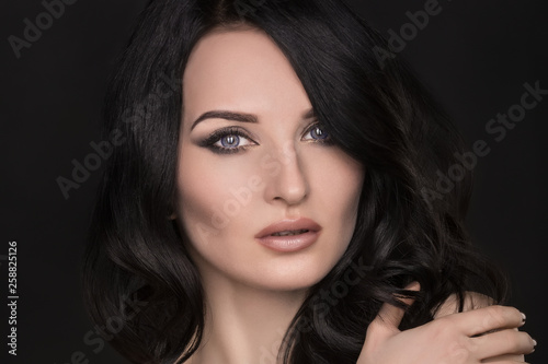Portrait of a sexy brunette with an elegant hairstyle and evening makeup