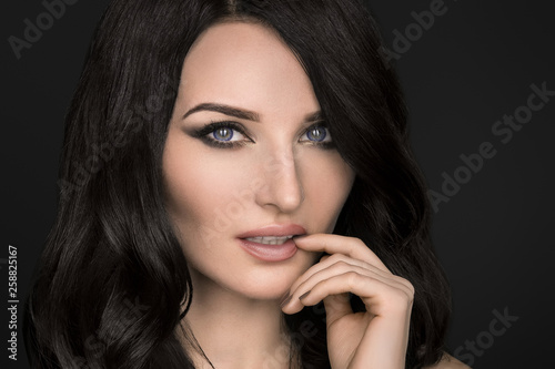 Portrait of a sexy brunette with an elegant hairstyle and evening makeup