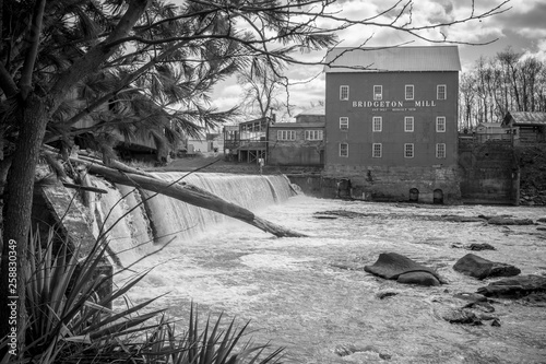 A Black and White photo Standing along the banks looking at the Bridgeton Grist Mill in Bridgeton, Indiana