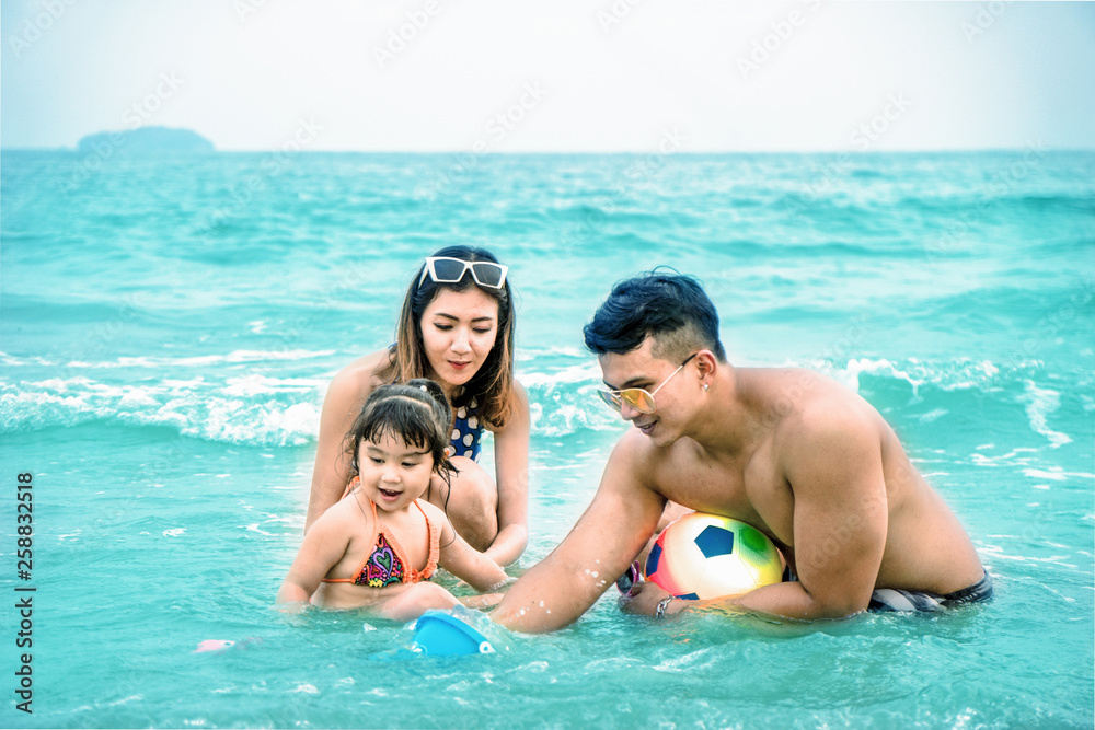 happy family having good time playing on beach and sea