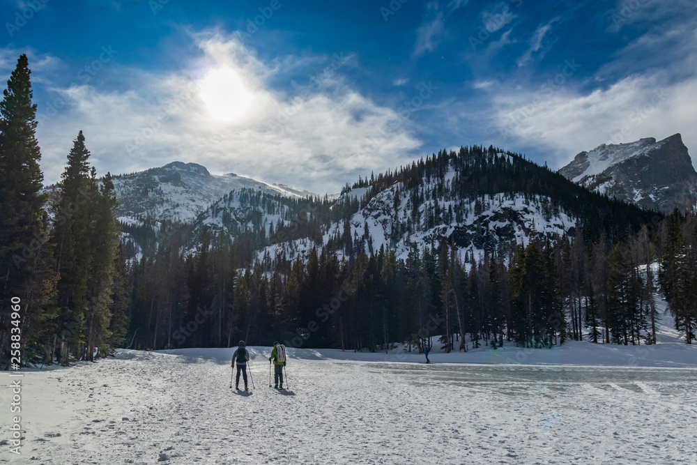 Skiers crossing frozen Nymph Lake, Rocky Mountain National Park, Colorado
