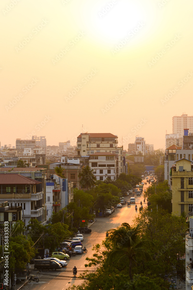 Daily traffic and city life on the busy streets of Mandalay during sunset. Mandalay is the second-largest city and the last royal capital of Myanmar (Burma)