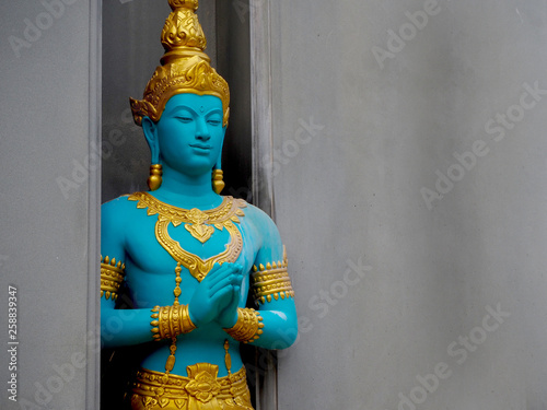 Buddha statue on the temple, Thailand. Blue body and gold dress are greeting. photo