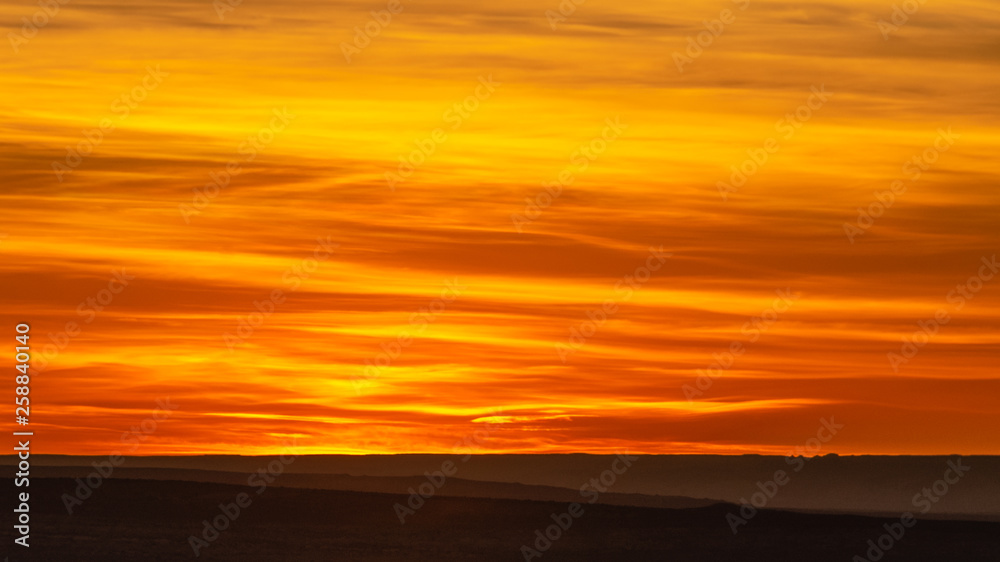 Dramatic orange and yellow sky with clouds at sunset