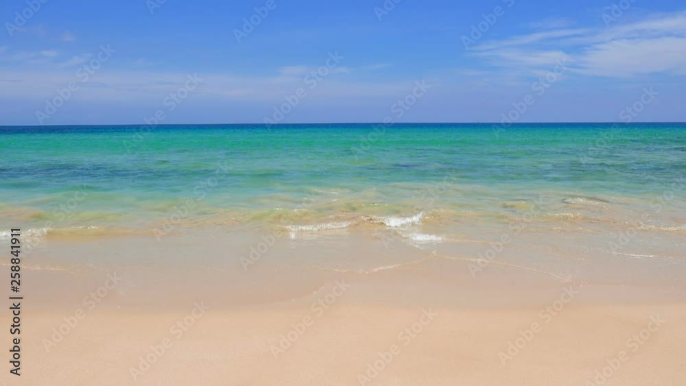 Calm waves splashing onto a tropical white beach with crystal clear waters. Calm waves splashing onto a tropical white beach with crystal clear waters.