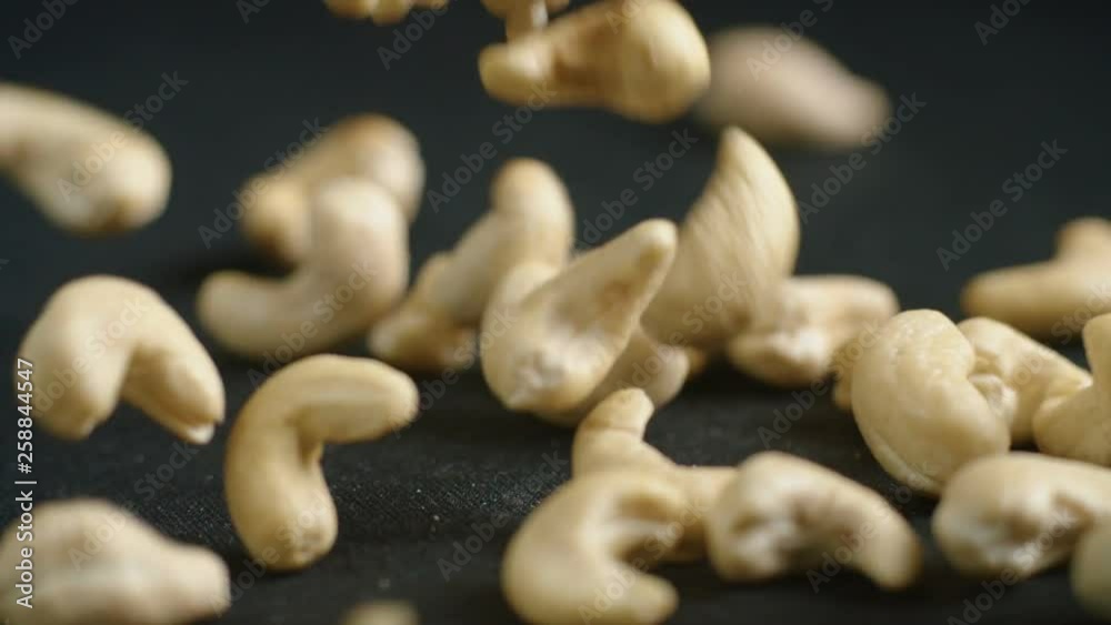 Almonds Falling down on a black surface