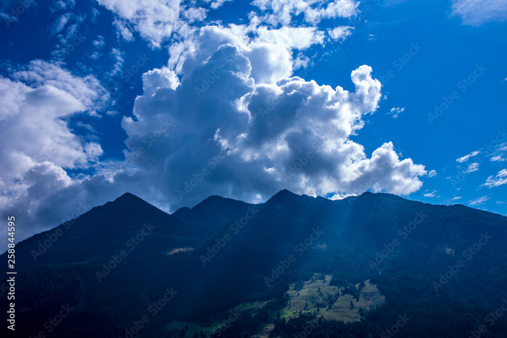Clouds and sunshine in a mountainous landscape. Concept weather.