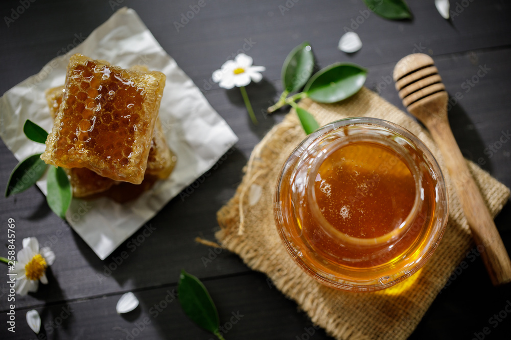 Organic honey and honeycomb on the wooden table, healthy products by organic natural ingredients concept Organic honey and honeycomb on the wooden table, healthy products by organic natural ingredients concept