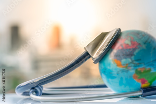 Green Earth day, Save the wold and Global healthcare concept. Stethoscope wrapped around globe on city background.