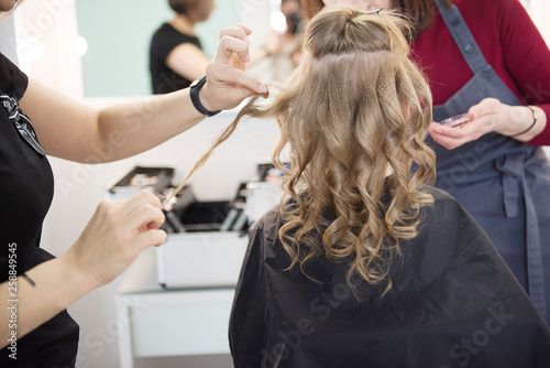 Hairdressing services. Сreating hairstyle. Hair styling process. Children's hairdressing salon.