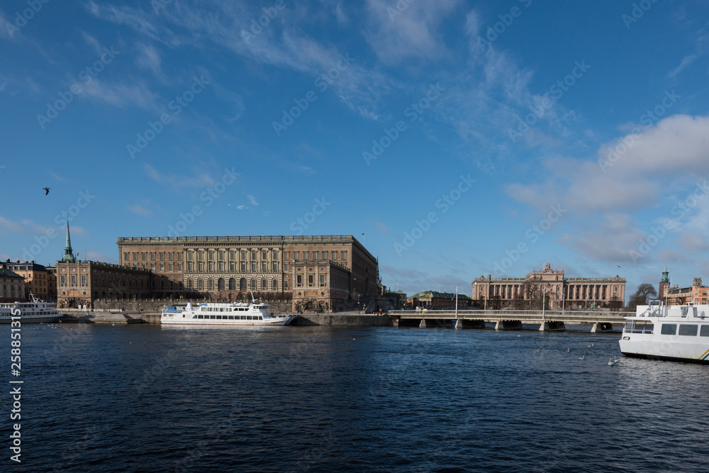 A sunny early spring day in Stockholm, view over a pier with boats and birds at the old town 