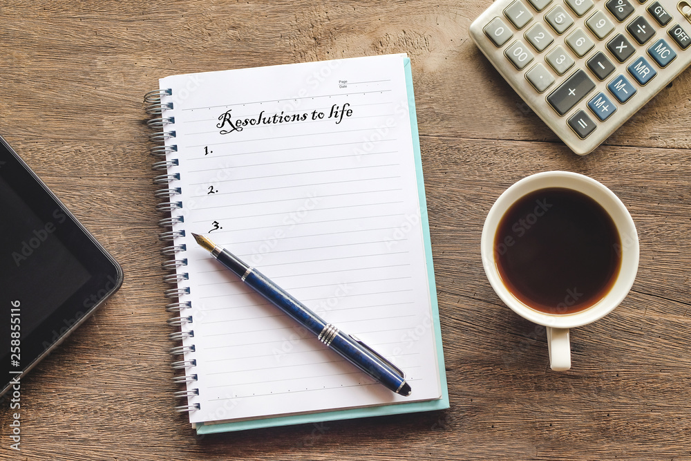 Resolutions to life text on book note with cup of coffee, pen and Resolutions to life text on book note with cup of coffee, pen and