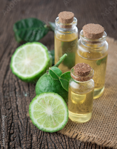 Fresh bergamot fruit and bergamot essential oil in glass bottle on wood table