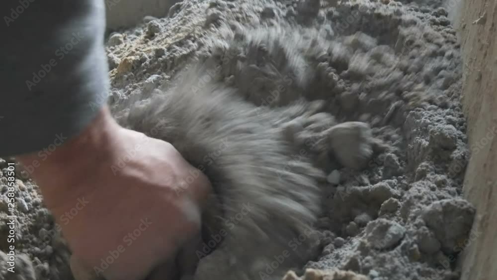 Male builder making cement. Blends cement clay and water, mixing all Male builder making cement. Blends cement clay and water, mixing all