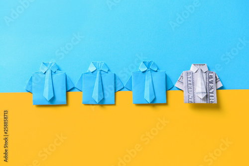 Konstfotografi Origami shirt made of dollar banknote among paper ones on color background