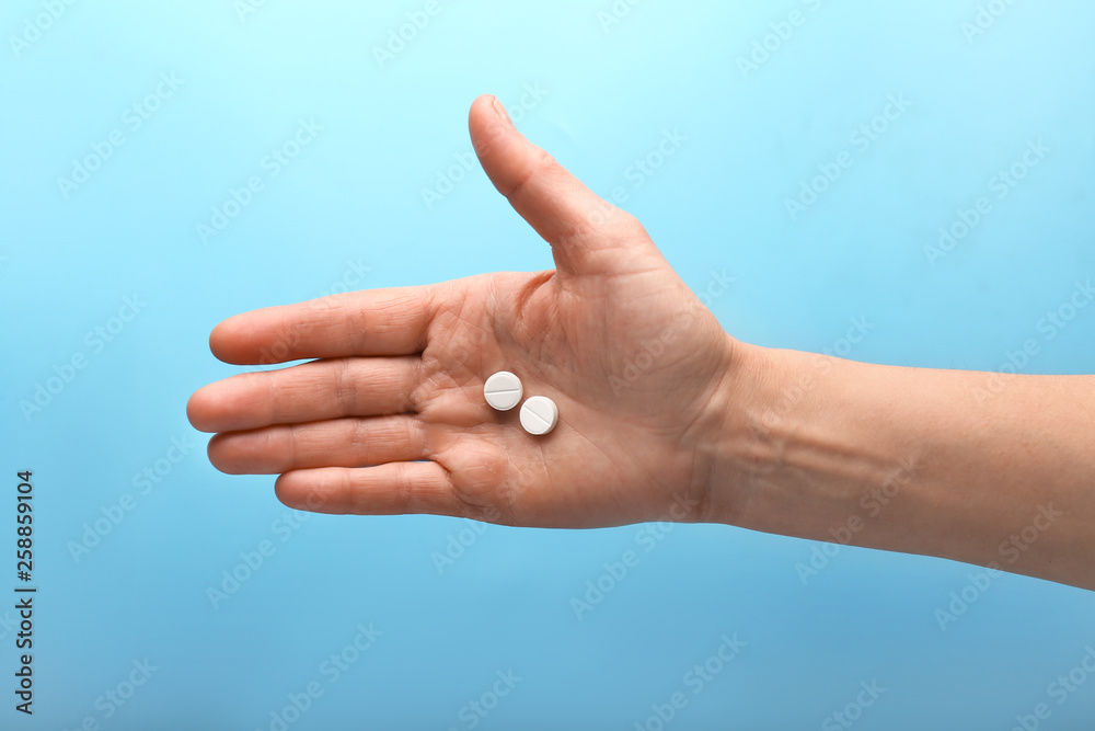Female hand with pills on color background Female hand with pills on color background