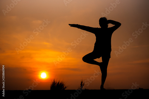 Silhouette Asia woman yoga on sunset. - Image