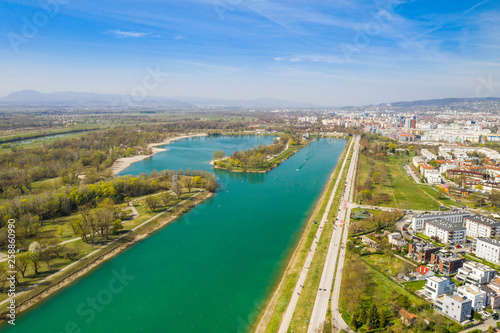 Zagreb  Croatia  Jarun lake  beautiful green recreation park area  sunny spring day  panoramic view from drone  city in background
