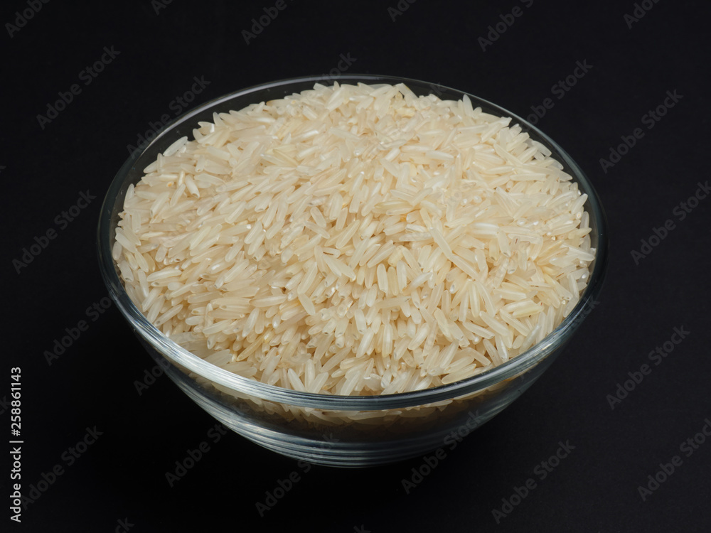 White basmati rice in a glass bowl on a black background White basmati rice in a glass bowl on a black background