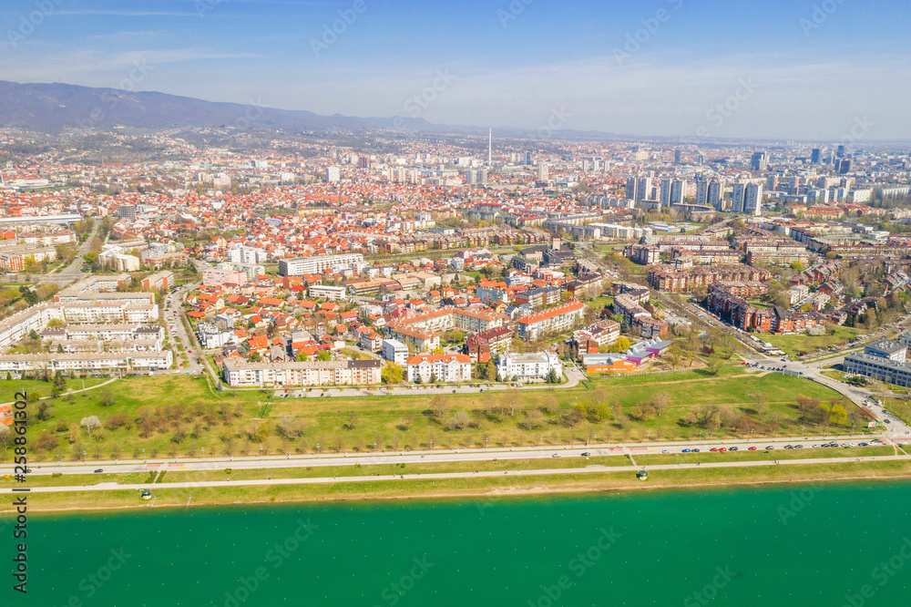 Naklejka premium Zagreb, Croatia, Jarun lake, beautiful green recreation park area, sunny spring day, panoramic view from drone, city in background