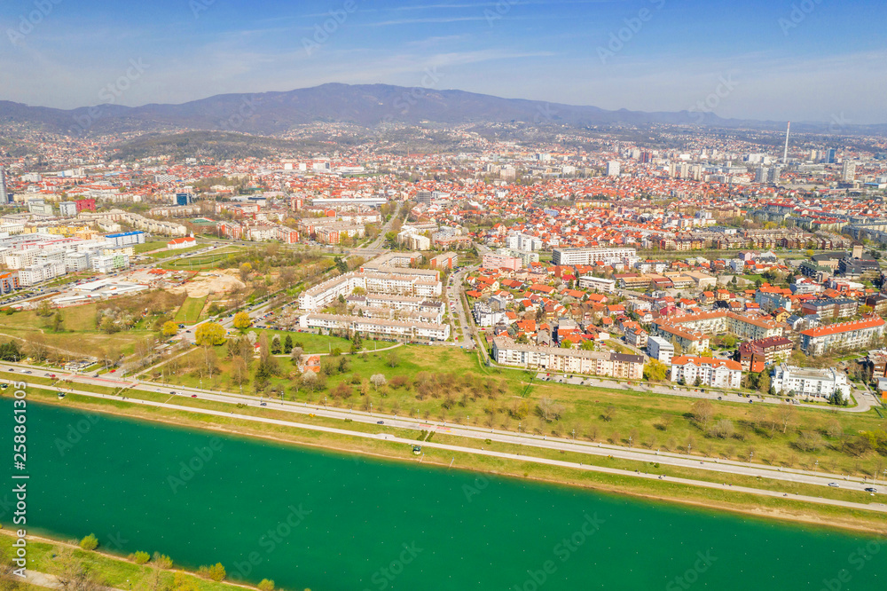 Zagreb, Croatia, Jarun lake, beautiful green recreation park area, sunny spring day, panoramic view from drone, city in background