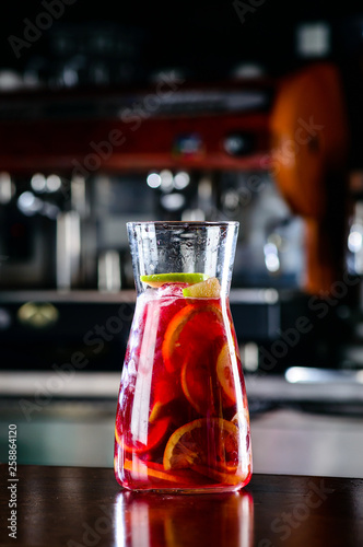 Sangria wine mixed with orange, apple in wine glass on black background