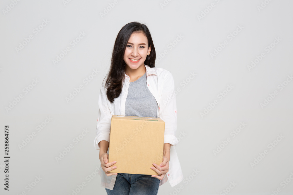 Delivery, relocation and unpacking. Smiling young woman holding cardboard box isolated on white background Delivery, relocation and unpacking. Smiling young woman holding cardboard box isolated on white background