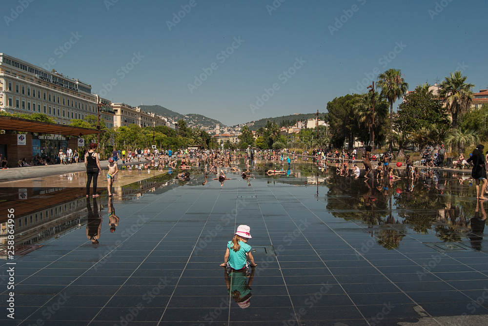 girl playing with water in Sun Fontaine in Nice, France