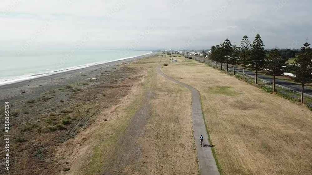 Aerial shot, tracking on a person cycling on the bike track in napier, new zealand (rear shot behind 2) Aerial shot, tracking on a person cycling on the bike track in napier, new zealand (rear shot behind 2)