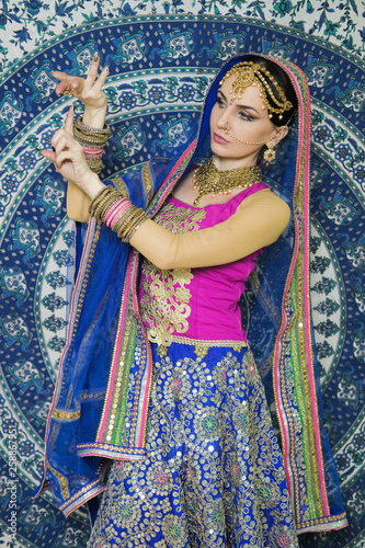 Woman in indian clothes dancing belly dance. Young beautiful woman in national costume dancing tribal dance.