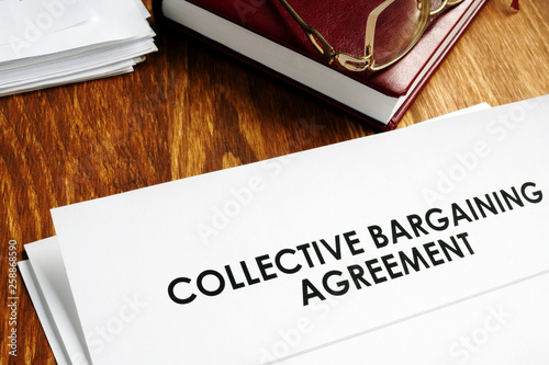 Collective bargaining agreement and note pad with glasses. photo