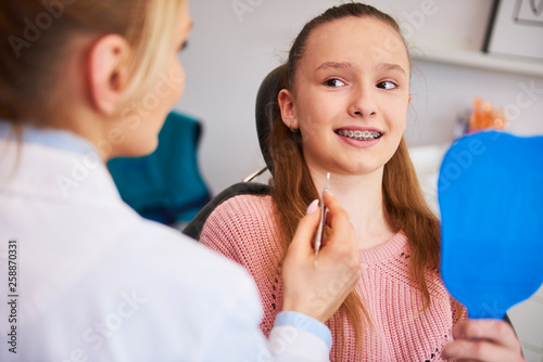 Terrified girl looking at female orthodontist