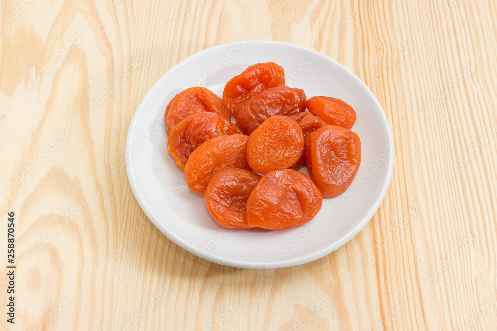 Dried apricots on the white saucer close-up Dried apricots on the white saucer close-up