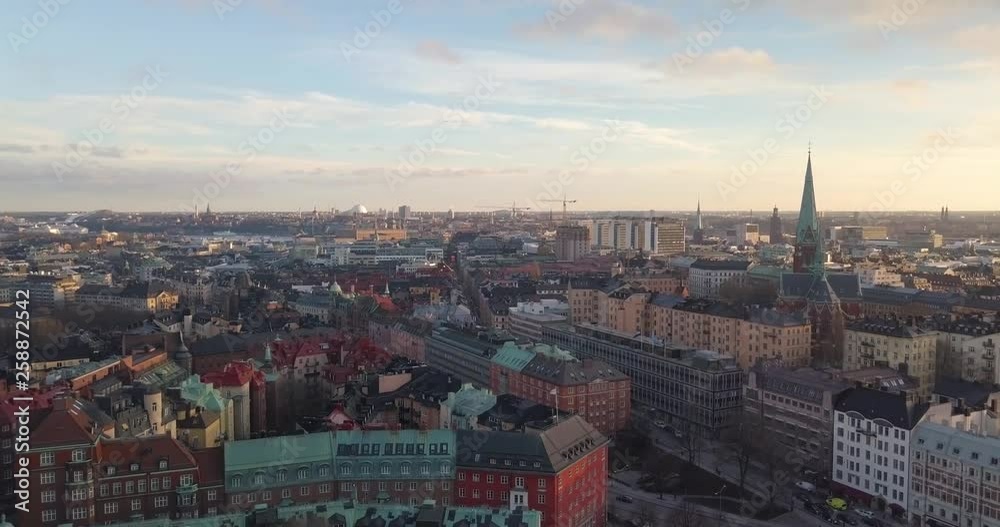 Wonderful aerial view early spring sunset Stockholm Sweden. Drone flies backward over Ostermarlm. Beautiful Swedish urban golden hour, stunning fluffy cloudscape. Colorful city horizon. Wonderful aerial view early spring sunset Stockholm Sweden. Drone flies backward over Ostermarlm. Beautiful Swedish urban golden hour, stunning fluffy cloudscape. Colorful city horizon.