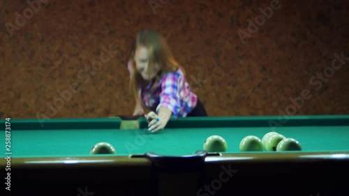 Young blonde woman plays in russian billiards. photo