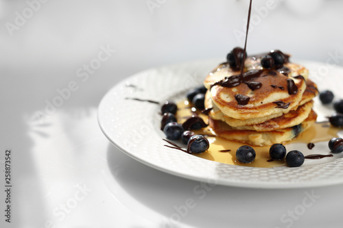 Sweet breakfast. Pancakes with blueberries and maple syrup. 