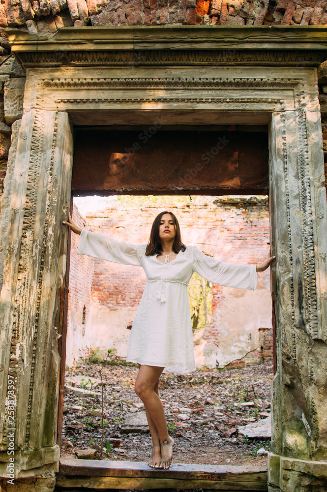 Beautiful brunette girl in arch of abandoned building