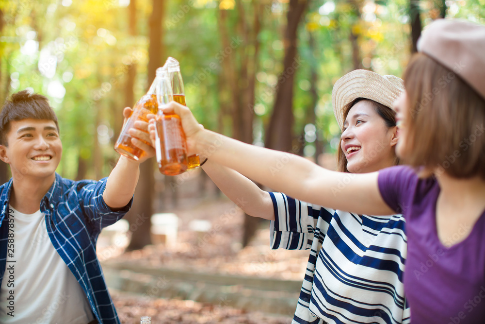 Naklejka premium young Friends hands toasting beer and having fun cheering