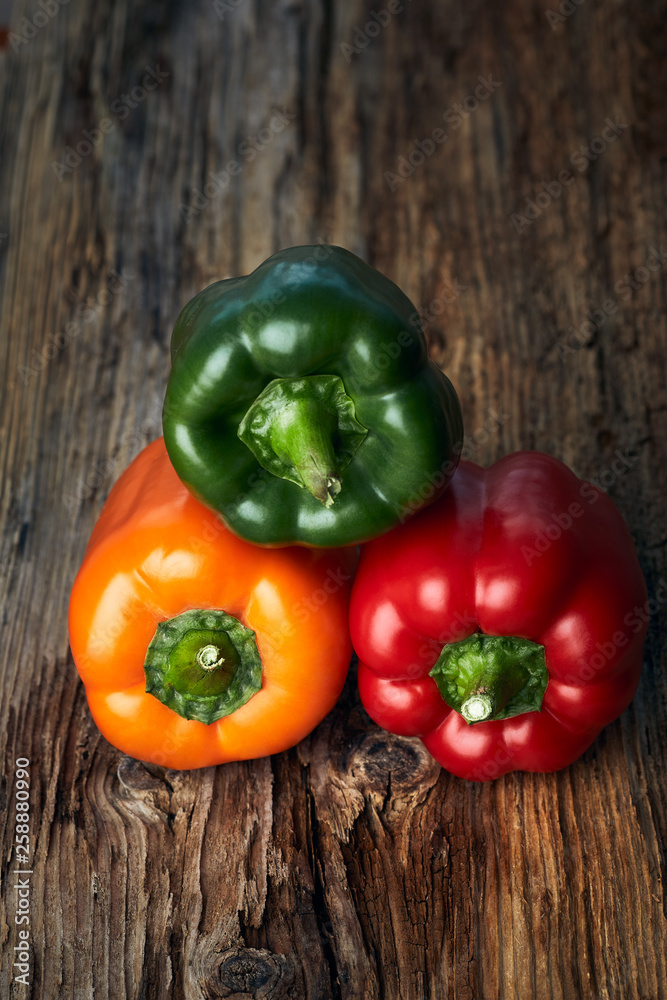 Colorful green, yellow, and red peppers paprika on wooden background Colorful green, yellow, and red peppers paprika on wooden background