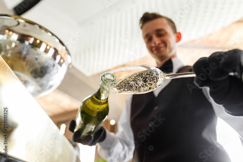 sommelier pours wine into a glass