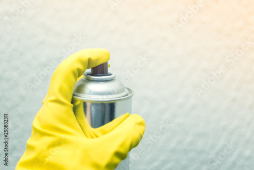 painting the walls of the spray. hand in yellow rubber gloves holding spray paint. repairs. photo