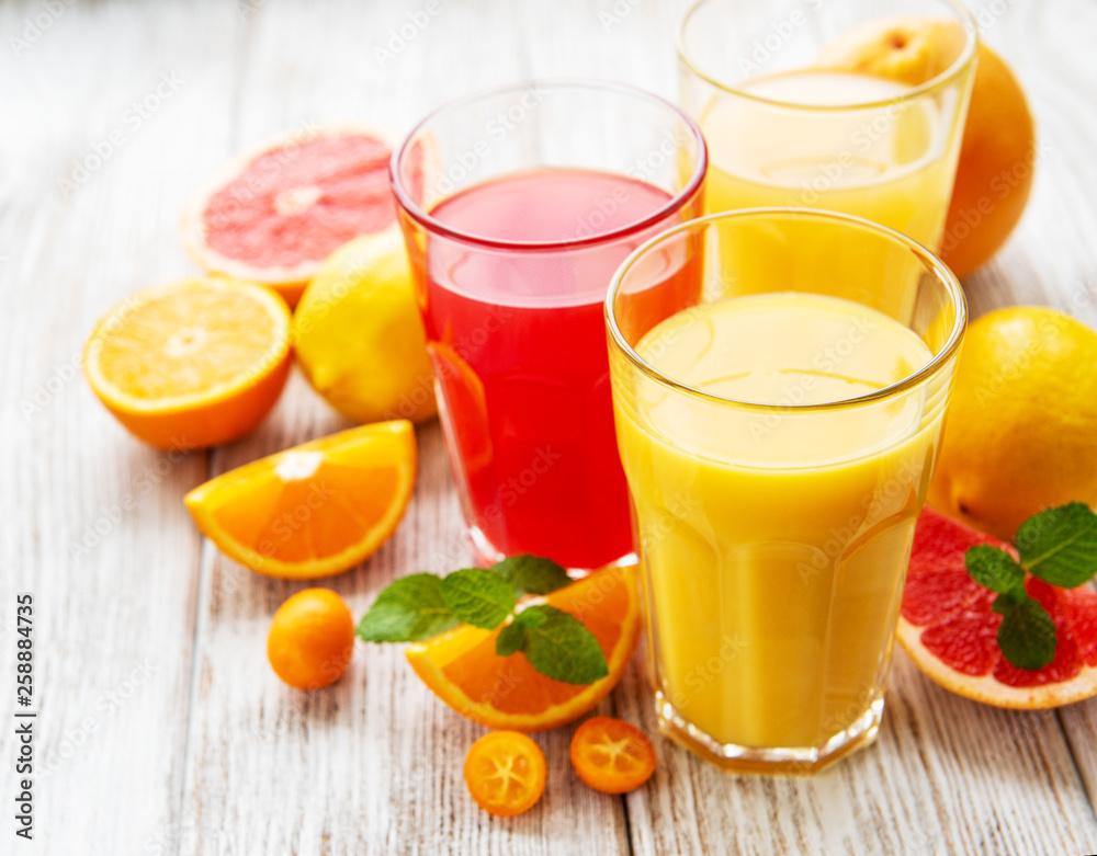 Glasses of juice and citrus fruits Glasses of juice and citrus fruits
